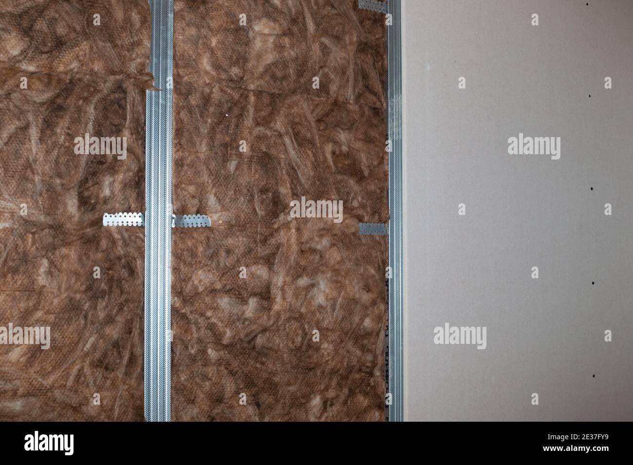 Isolierung und Schalldämmung der Wände mit Mineralwolle, vor der Verkleidung mit Gipskarton. Renovierung des Hauses. Stockfoto