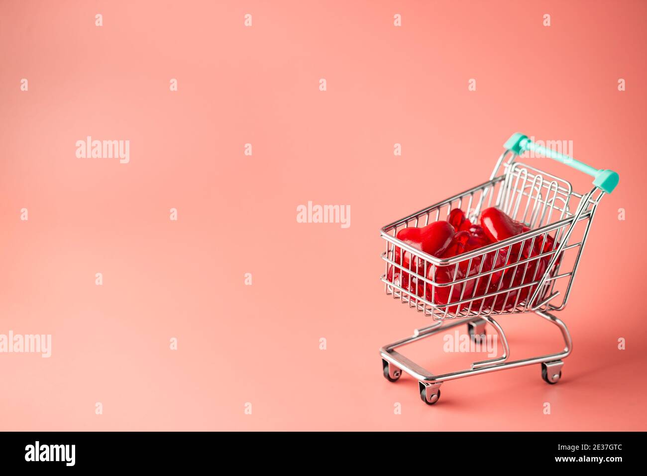 Warenkorb voller Herzen zum Valentinstag auf rosa Hintergrund Stockfoto