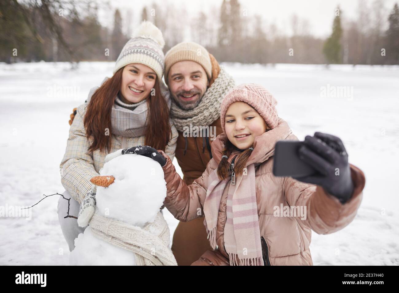 Porträt der glücklichen Familie Selfie-Foto im Freien beim Bau Schneemann zusammen und genießen Winterurlaub, kopieren Raum Stockfoto