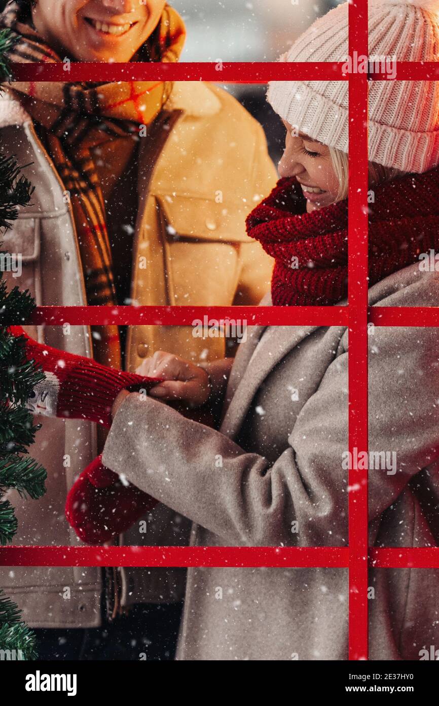 Romantisches Paar Spaß im Winter vor Weihnachten, lächelnd, stehend in roten Telefonzelle Stockfoto