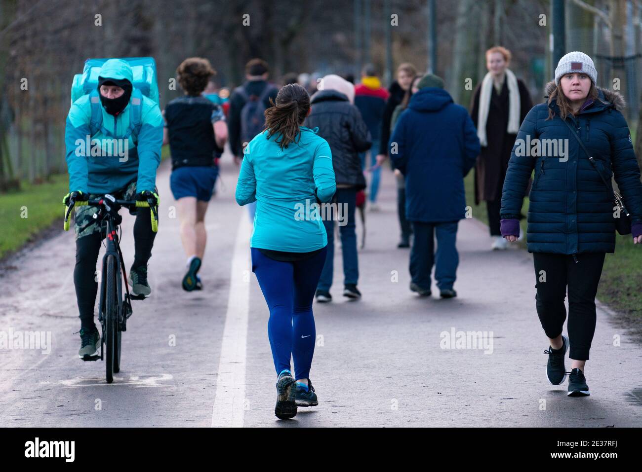 Edinburgh, Schottland, Großbritannien. 17. Januar 2021. Am ersten Sonntag nach Verschärfung der nationalen Sperrregeln in Schottland war die Öffentlichkeit in großer Zahl im Meadows Park in Edinburgh. Zwischen Spaziergängern, Joggern und Radfahrern wurde sehr wenig soziale Distanz aufrechterhalten, da sie auf einem schmalen Fußweg um Platz wetteiferten. Iain Masterton/Alamy Live News Stockfoto