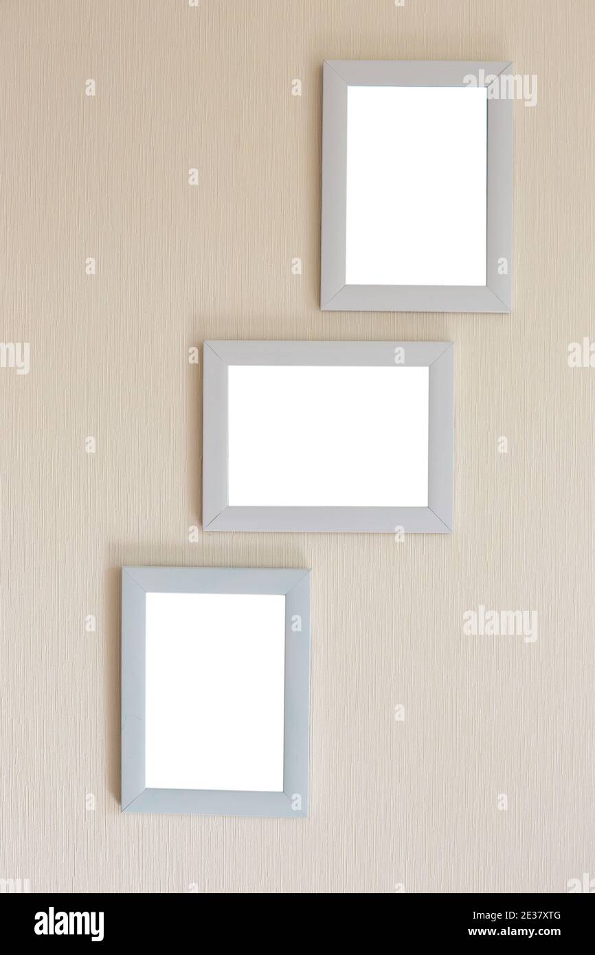 Collage aus drei weißen Rahmen auf einer beigen Wand Stockfoto