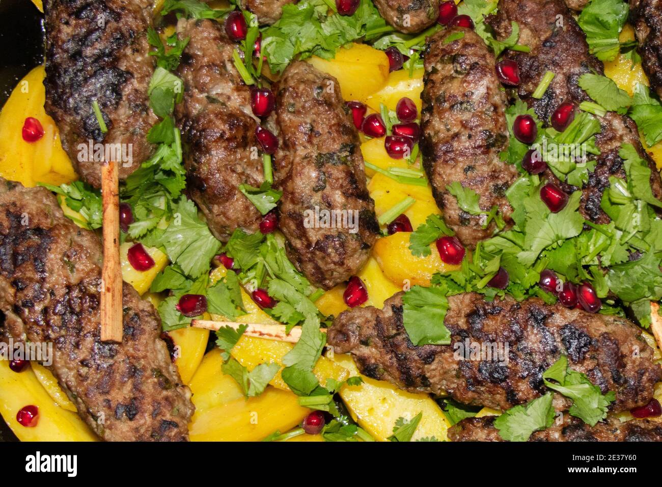 Gegrillte Fleischbällchen mit Kartoffeln und Kräutern in Backform. Flach liegend Stockfoto