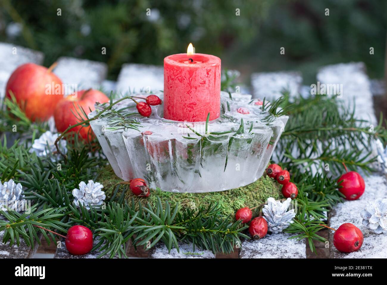 weihnachtsdekoration mit Eislaterne, roter Kerze und Eibenzweigen Stockfoto