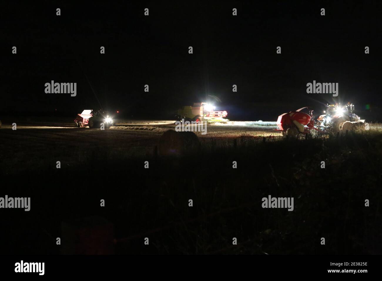 Ayrshire, Schottland, Großbritannien. Nachtaufnahmen Traktoren bei der Arbeit bringen die Ernte ein. Mähdrescher tragen den Namen vom Ernten, Dreschen, Sammeln und Winnieren in einem Prozess Stockfoto