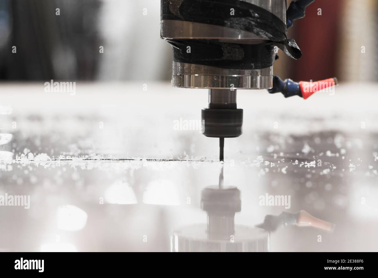 Endfräser verarbeitet ein Kunststoffblech auf einer CNC-Fräsmaschine, Nahaufnahme mit selektivem Weichfokus Stockfoto