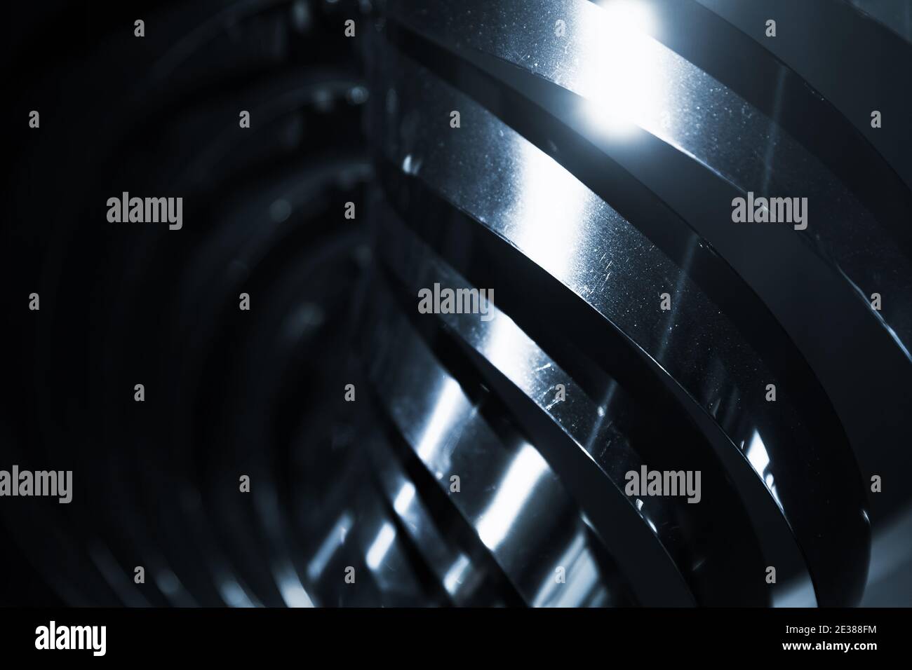 Abstrakt glänzend schwarz Metall Spiralstruktur, blau getönten monochromen industriellen Hintergrund Foto Stockfoto