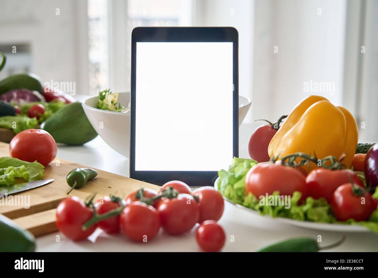 Digitaler Tablet-Computer mit Mockup-weißen Bildschirm auf Lebensmittel Gemüse Hintergrund. Stockfoto