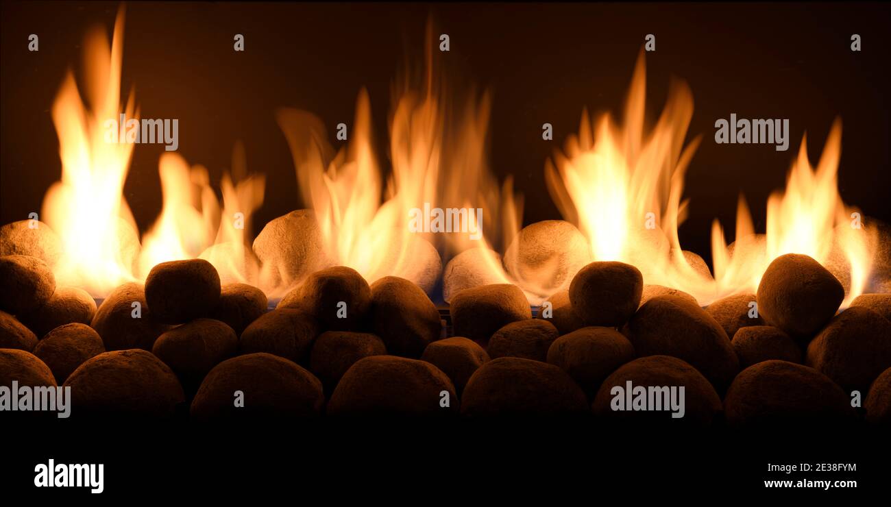 Gelbe Flammen von einem Gasfeuer mit Steinen in der Kamin Stockfoto