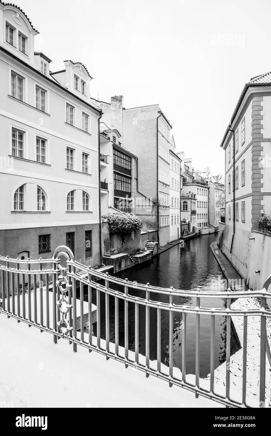 Winter in Prag Venedig. Wohnhäuser am Devils Stream oder Devils Channel, Tschechisch: Certovka, in der Nähe der Karlsbrücke in Prag, Tschechische Republik. Schwarzweiß-Bild. Stockfoto