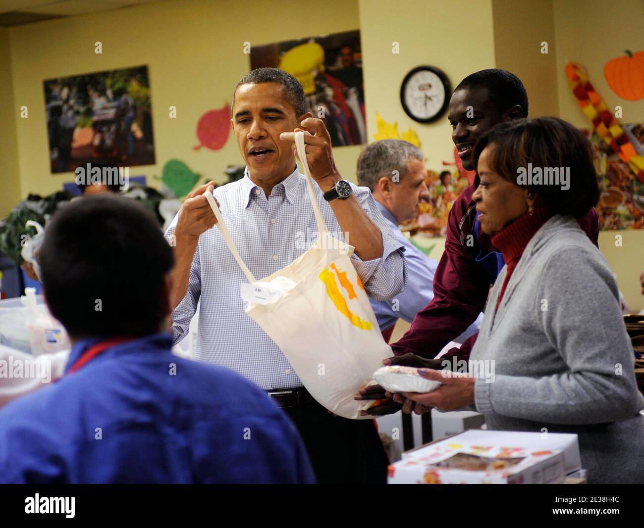 US-Präsident Barack Obama verpackt und liefert mit Hilfe seiner Schwiegermutter Marian Robinson am 24. November 2010 am Martha's Table in Washington Lebensmittelbeutel an die Bewohner der Gegend. Foto von Leslie E. Kossopf/Polaris Pool/ABACAUSA.COM Stockfoto