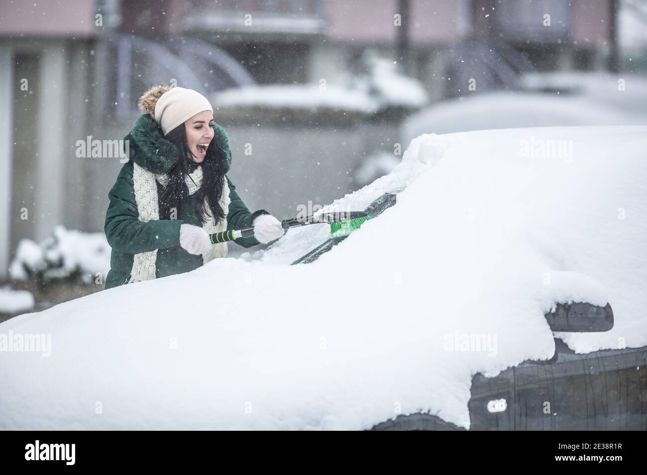 Reinigung des Autos aus Schnee mit Stockfoto 1875784192