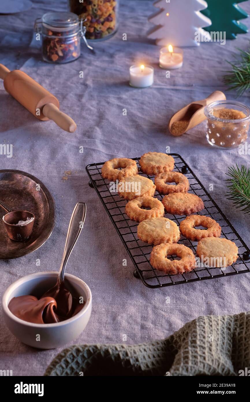 Sandwichkekse gefüllt mit Haselnussaufstrich, Nougatcreme. Weihnachten Linzer Cookies auf Kühlgestell gefüllt, Metallplatte. Wintereinrichtung, Bettwäsche Stockfoto