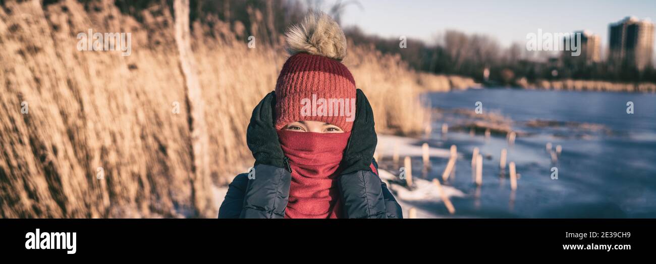 Kaltes Wetter Winter Gesichtsschutz Frau, die Ohren mit Zubehör Handschuhe, Hut, Schal Gefühl sehr kalt Panorama-Banner. Lustige Aktivitäten im Freien Stockfoto