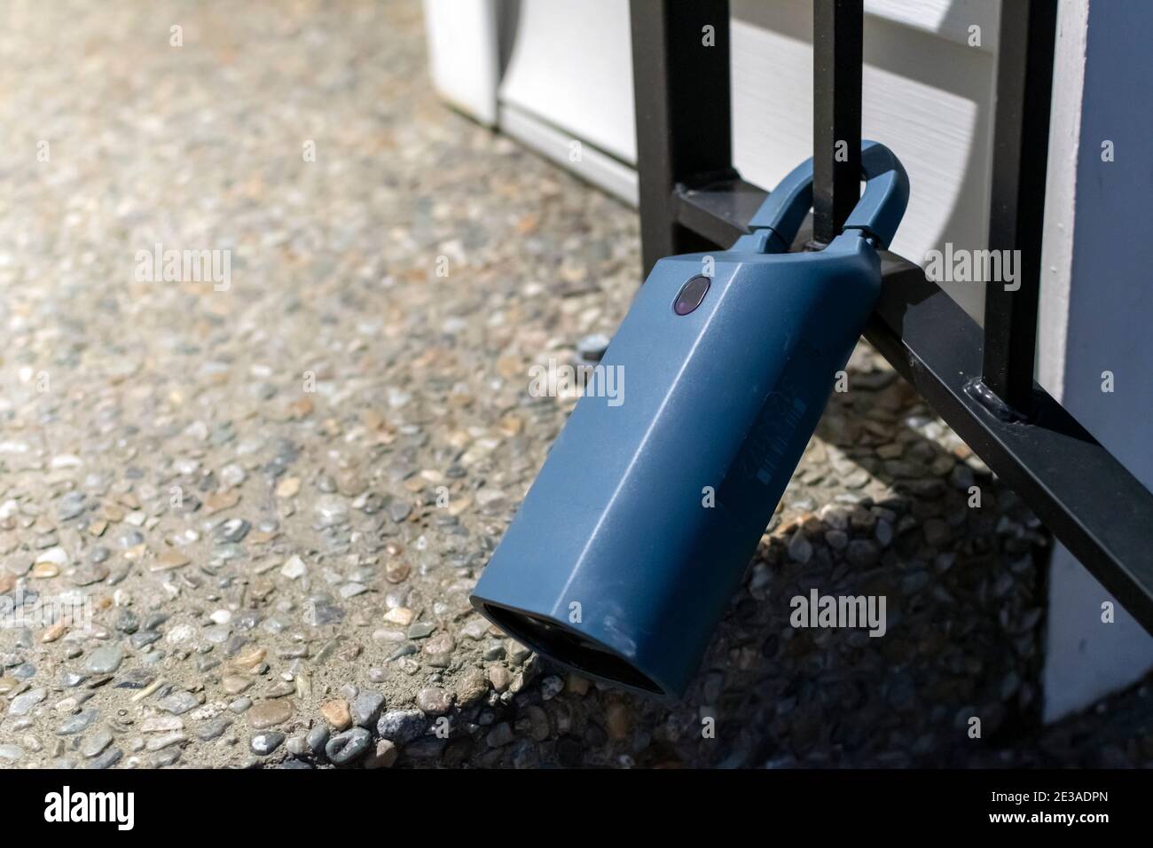 Eine elektronische Lockbox, die durch einen Remote-Code aktiviert wird, ist an der Eisengeländer eines Hauses angebracht. Stockfoto