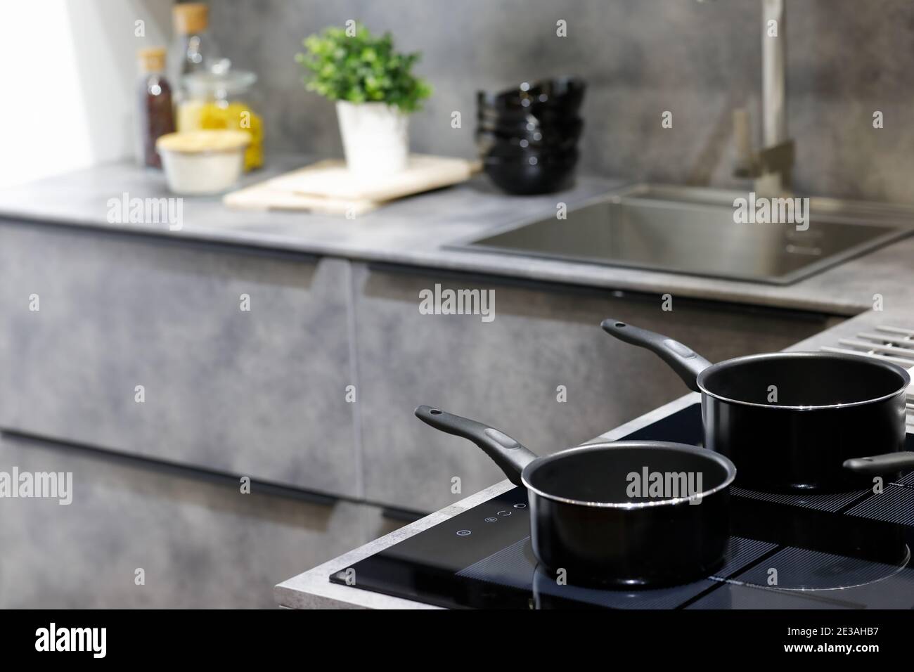 Moderne Küche mit Antihaft-Kochtöpfen auf einem Induktionsherd. Selektiver Fokus. Stockfoto