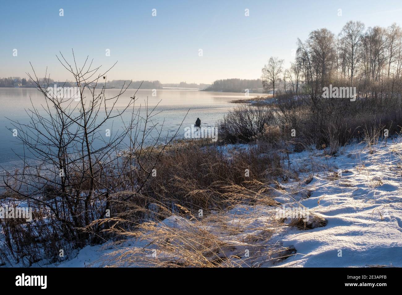 Fischer auf dem Eis eines großen Flusses an einem sonnigen Wintertag, Russland. Stockfoto