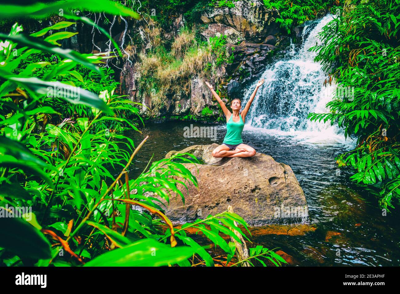 Yoga Natur Wellness Meditation Retreat Frau im tropischen Wasserfall Wald in Kauai, Hawaii. Glückliches Mädchen mit offenen Armen in Gelassenheit genießen üppig Stockfoto