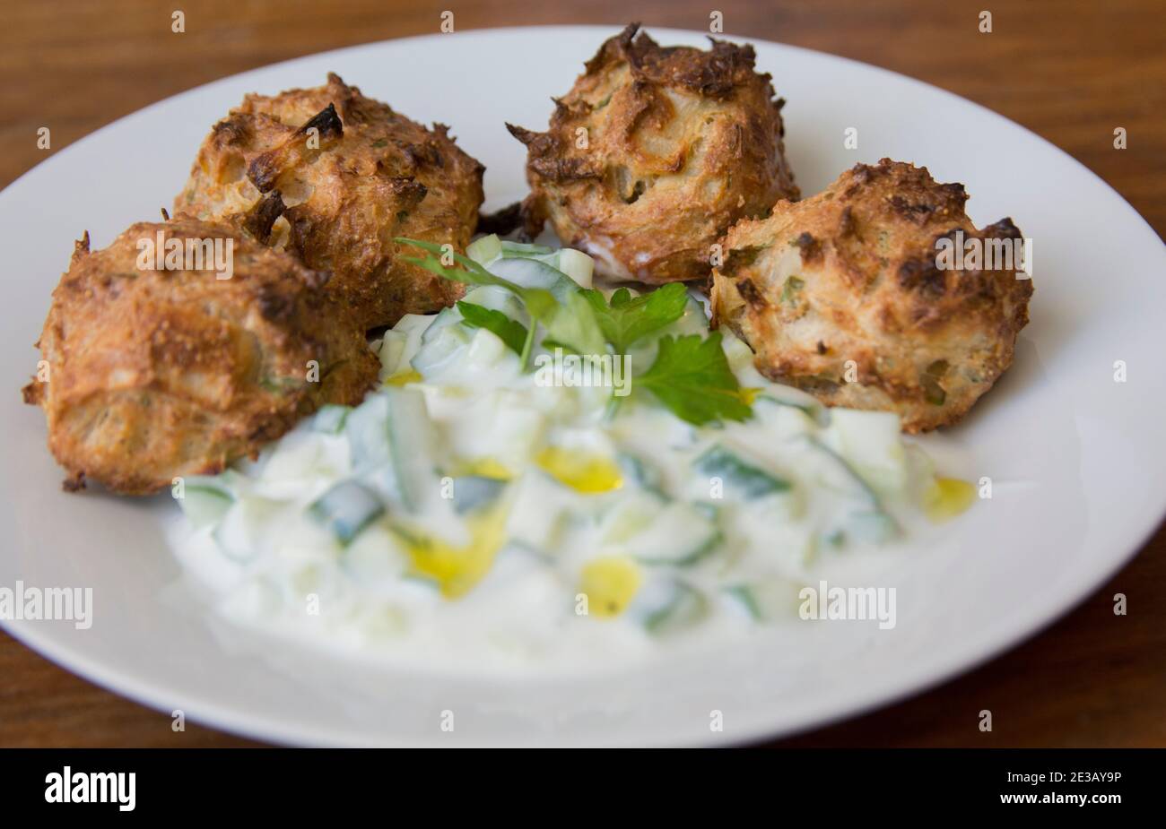 Traditionelle griechische Patties aus Lauch und Käse, serviert mit Tzatziki-Sauce auf einem Teller Stockfoto