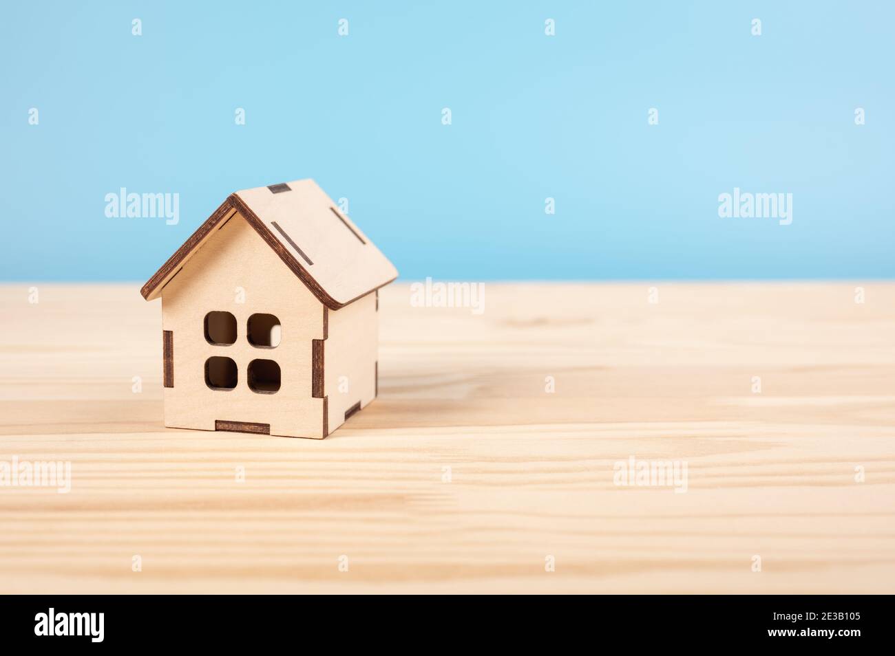 Spielzeughaus auf Holztisch auf blauem Boden. Hypothek-Immobilien-Versicherung Traum-Haus-Konzept. Kopieren Raum. Haus, Versicherung und Hypothek, Bul und ren Stockfoto