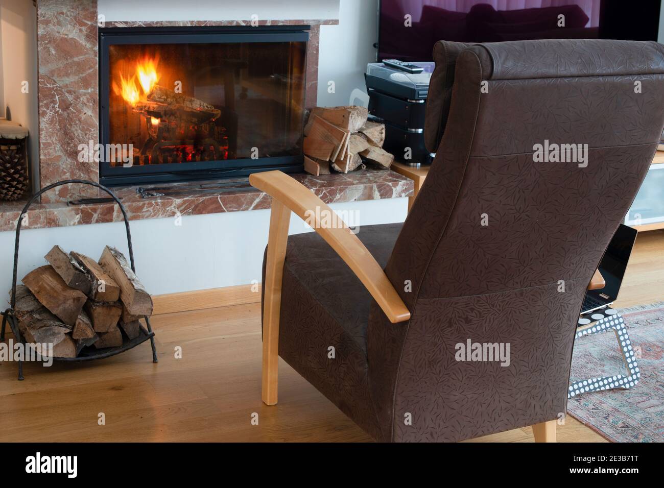 Sessel am Kamin im Wohnzimmer. Konzept der Entspannung und Gemütlichkeit. Stockfoto