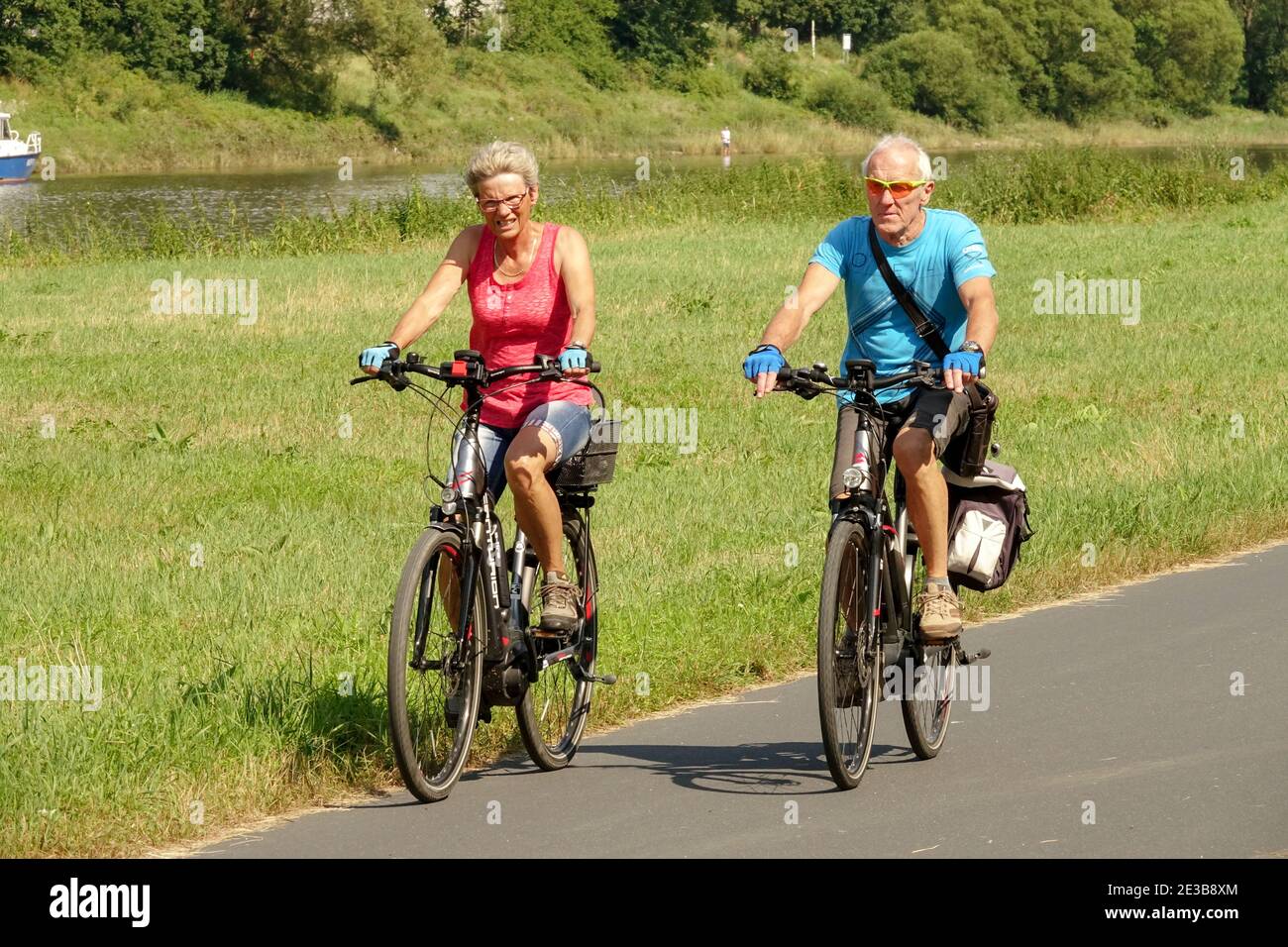 Seniorenpaar Radfahren Sommer Deutschland Urlaub Mann Frau draußen auf einem E-Bike, gesunde Lebensweise Radfahren Deutschland alte Leute Seniorenpaar Lebensstil Stockfoto