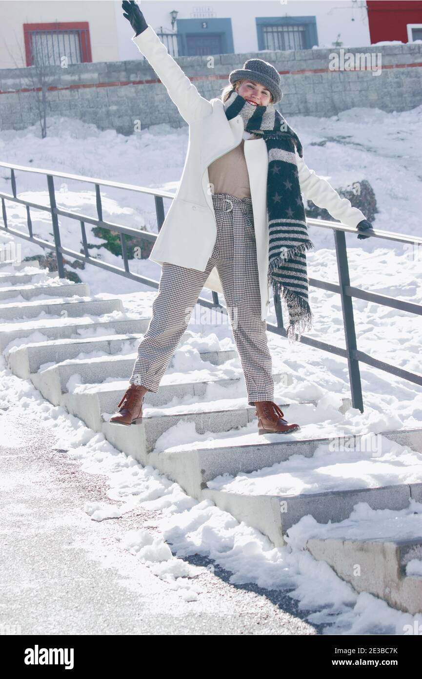 Schöne Frau lächelt glücklich zur Kamera nach einem verschneiten Tag an einem Wintertag. Schneefotografie 2021. Stockfoto