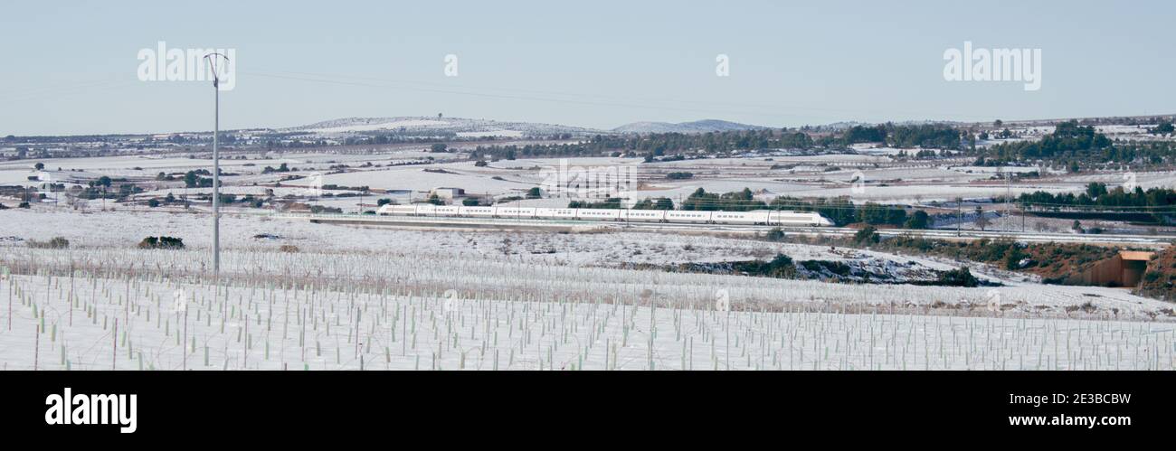 Frostige Winterberge, während ein Schnellzug mit voller Geschwindigkeit direkt zum Ziel fährt. Panoramablick auf Valencia in Spanien von einem Wintertag 2021. Stockfoto