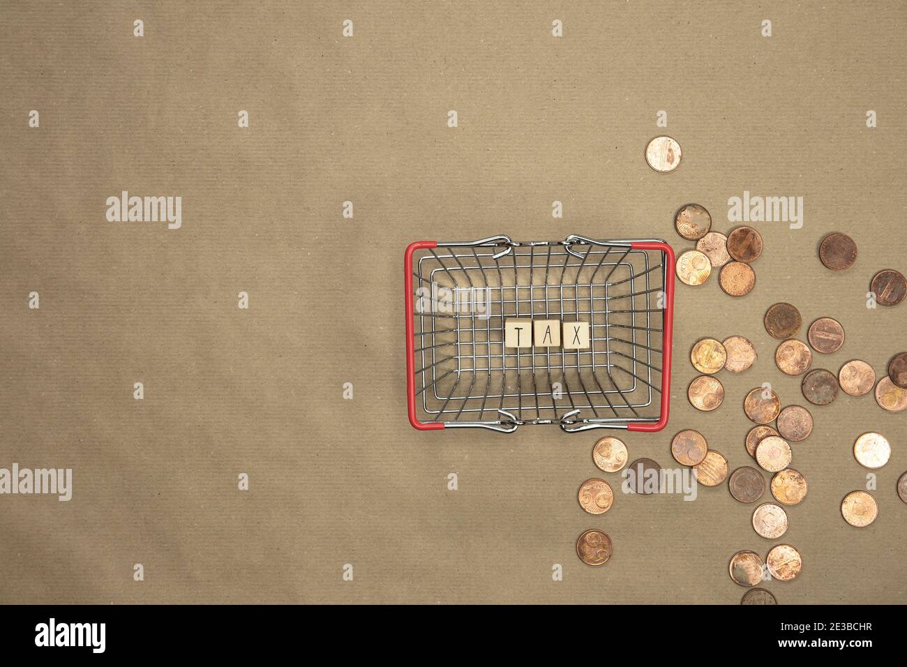 Steuer geschrieben mit Holzwürfeln Draufsicht im Warenkorb mit Geldmünzen und Scheinen auf dem Hintergrund. Geschäfts- und Finanzkonzept Stockfoto
