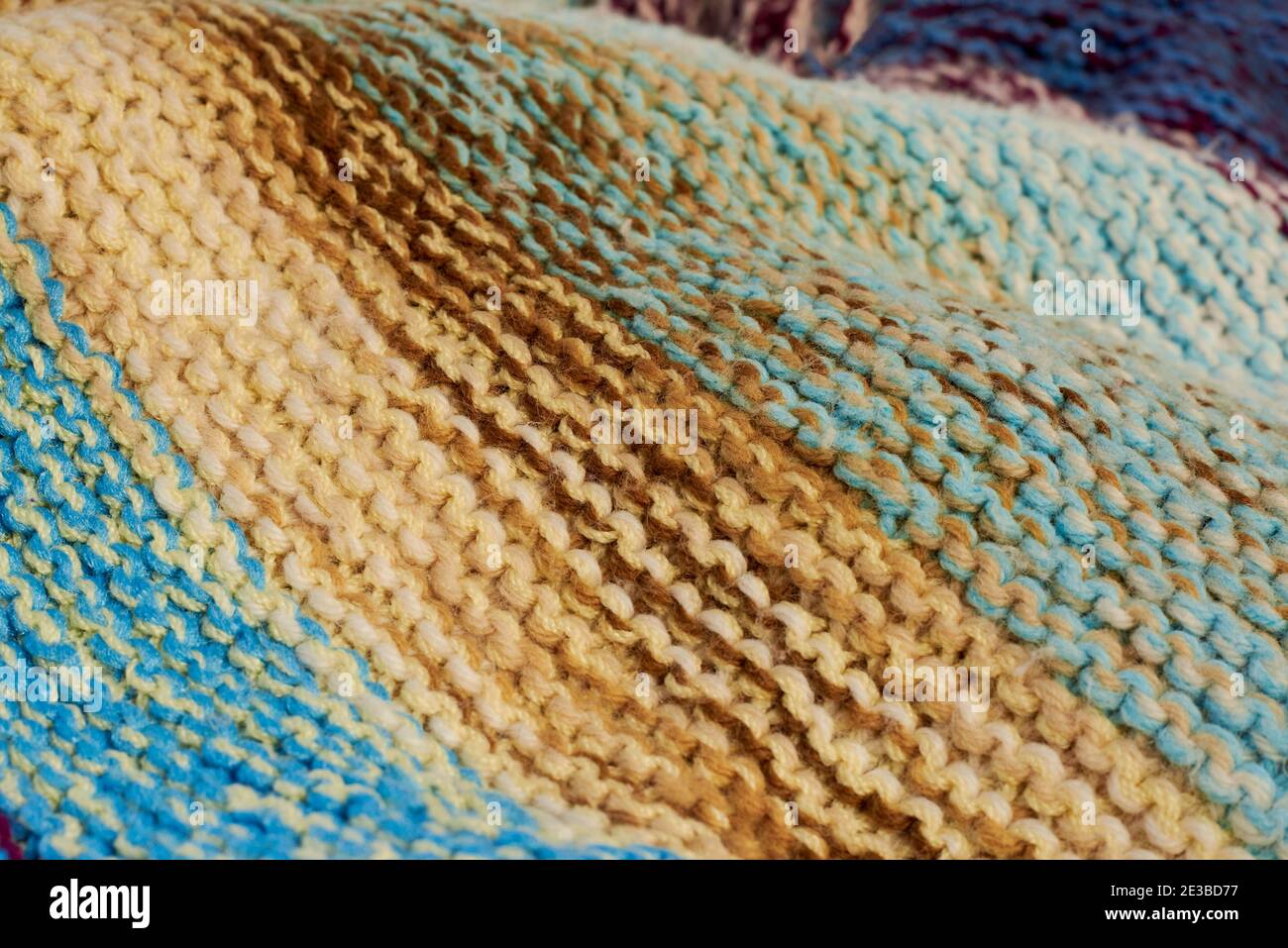 Gestrickte mehrfarbige Wolle handgemachte Karo, Nahaufnahme, kreative Hintergrund. Stockfoto
