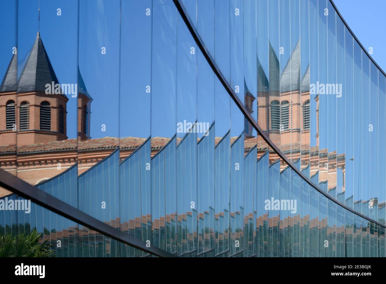 Abstraktes verzerrtes Bild des Naturhistorischen Museums mit Ziegelstein Turm reflektiert in Spiegelglas Moderne Exteension Toulouse Frankreich Stockfoto