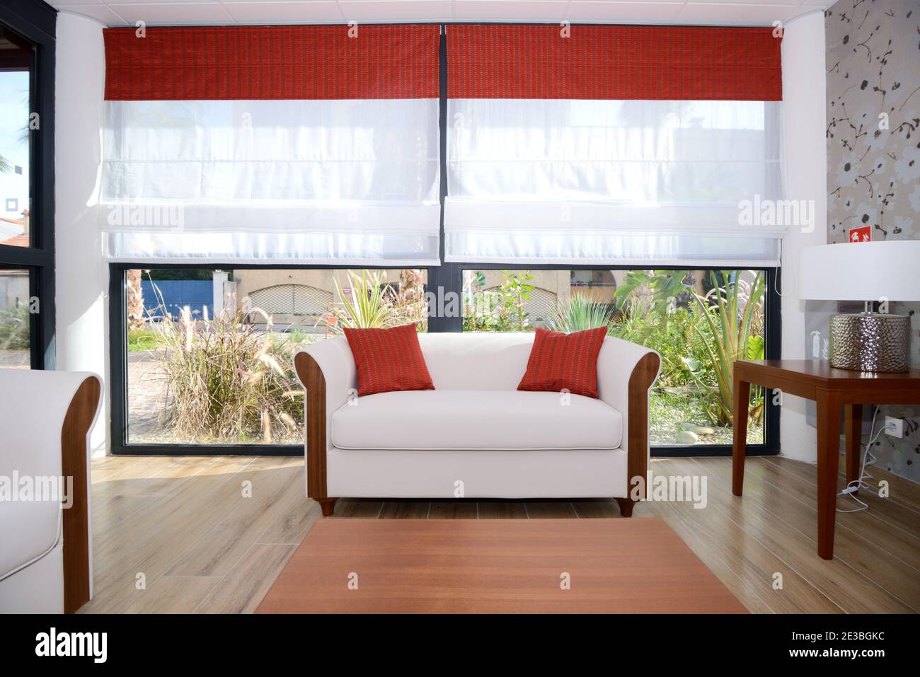 Minimalistisches weißes Wohnzimmer und Interieur mit weißem Sofa oder Sofa & Weiße Fensterläden Stockfoto