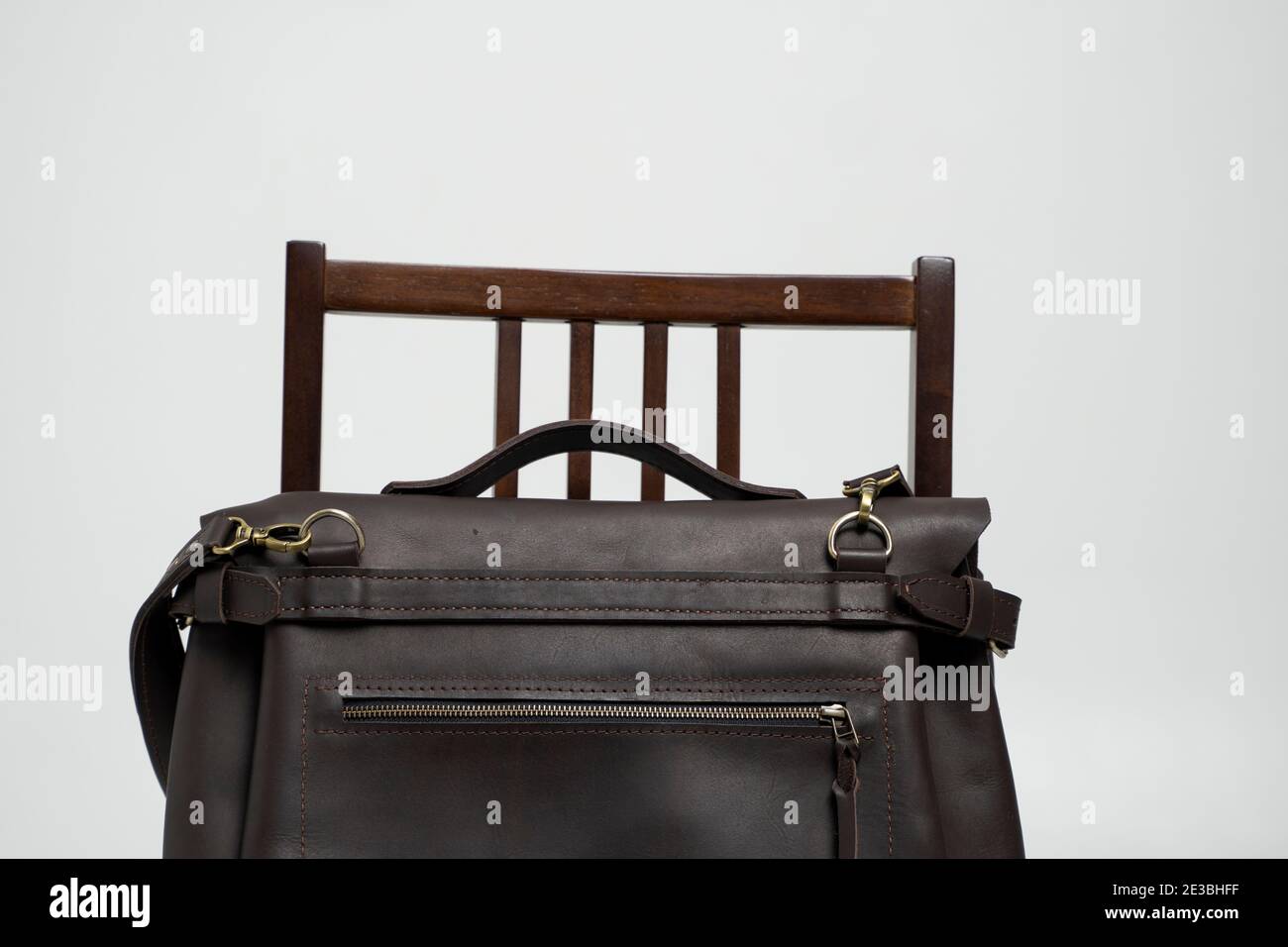 Braune Männer Schulterledertasche für Dokumente und Laptop auf einem  braunen Stuhl mit weißem Hintergrund. Herren Ledertasche, Kuriertaschen,  Leder Stockfotografie - Alamy