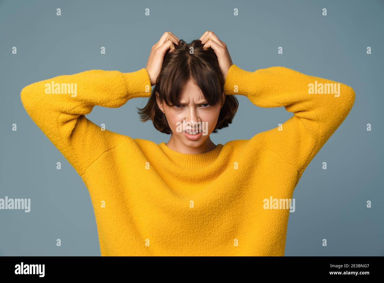 Porträt einer frustrierten wütenden Frau schreien laut und Ziehen ihr Haar isoliert auf blauem Hintergrund Stockfoto