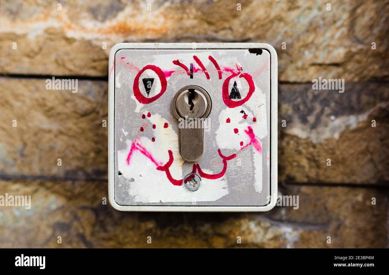 Kreative Schnauze auf Schlüsselloch gezeichnet. Das Schloss ist mit Straßenvandalismus bemalt. Farbe gezeichnet lächelnd positive Emoticon Stockfoto