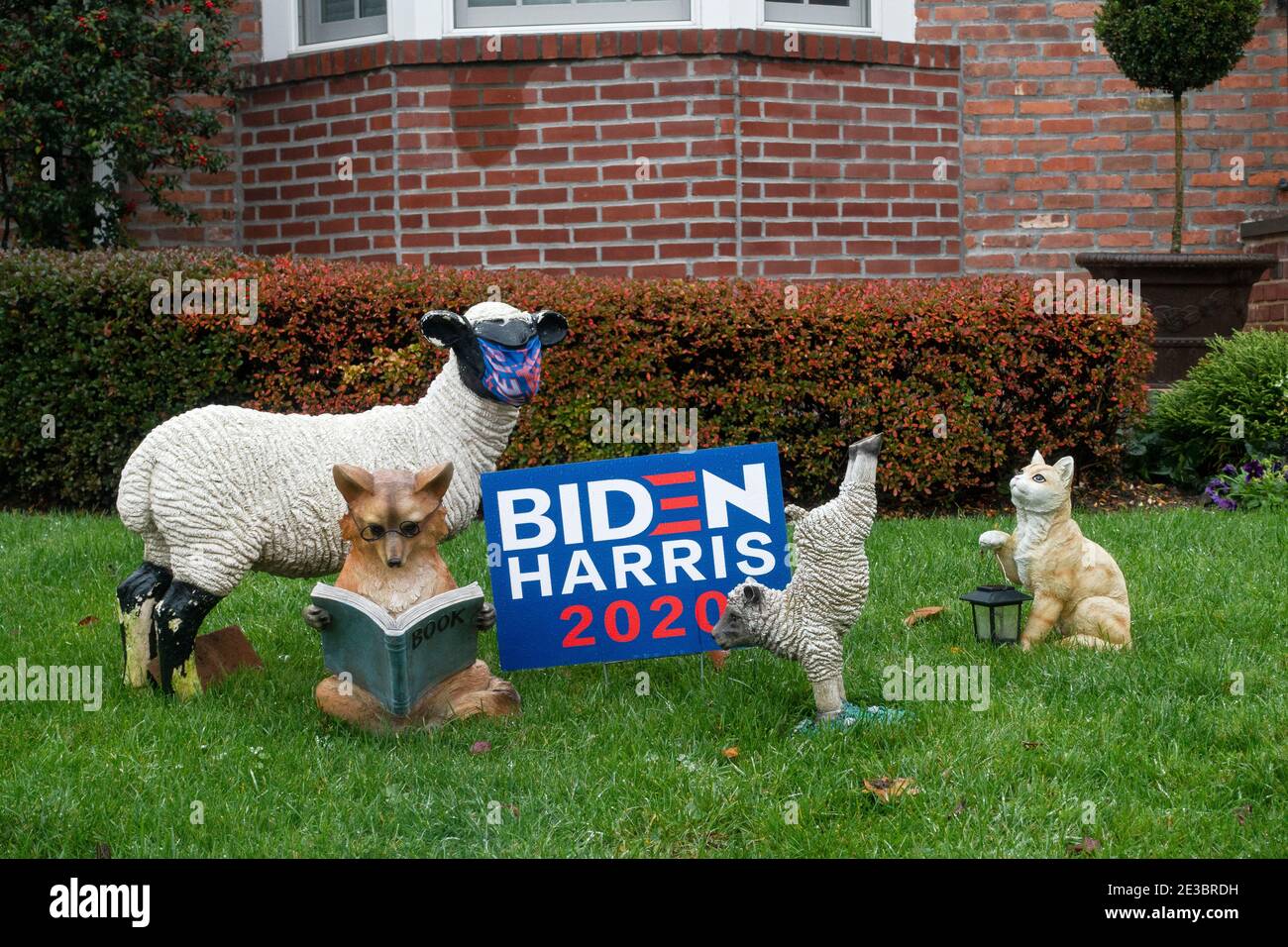 VOLKSKUNST + POLITIK. Keramiktiere umgeben ein Biden - Harris in 2020 Plakat auf einem Rasen in Queens, New York City. Stockfoto