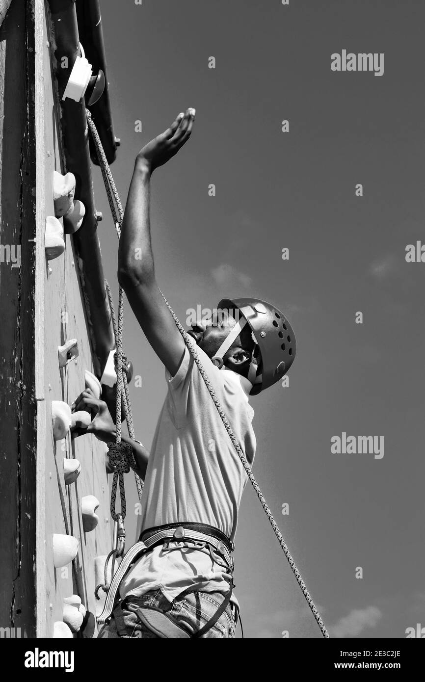 JOHANNESBURG, SÜDAFRIKA - 06. Jan 2021: Johannesburg, Südafrika - 8. Juni 2012: Afrikanischer Mensch, der Spaß an einer Kletterwand im Freien hat Stockfoto