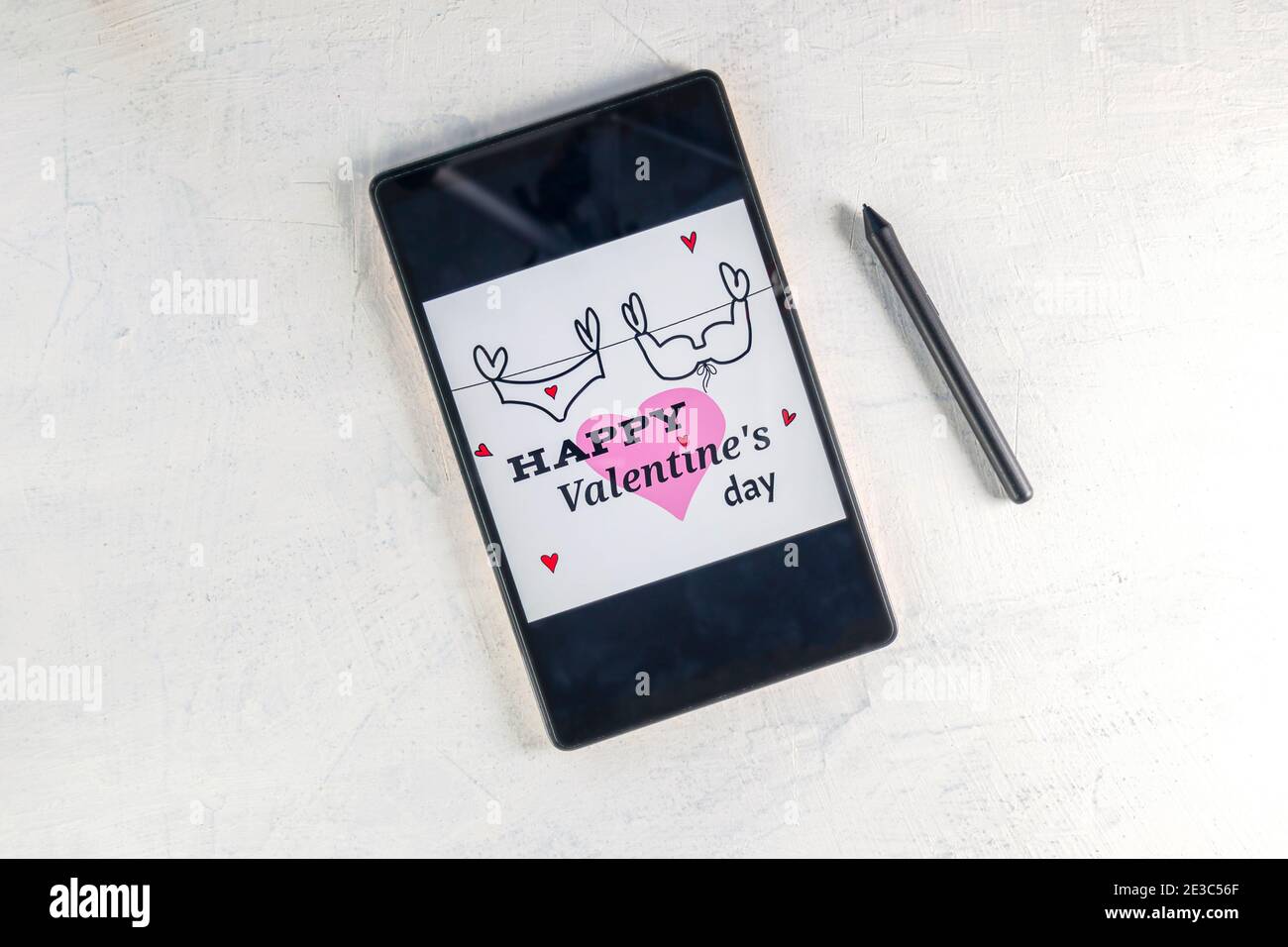 Tablet-Computer mit rosa Herz und Inschrift Alles Liebe zum Valentinstag. Tablet PC mit Valentine und Stylus Pen. Valentinstag Dekoration. Valentinstag-Konzept. Stockfoto
