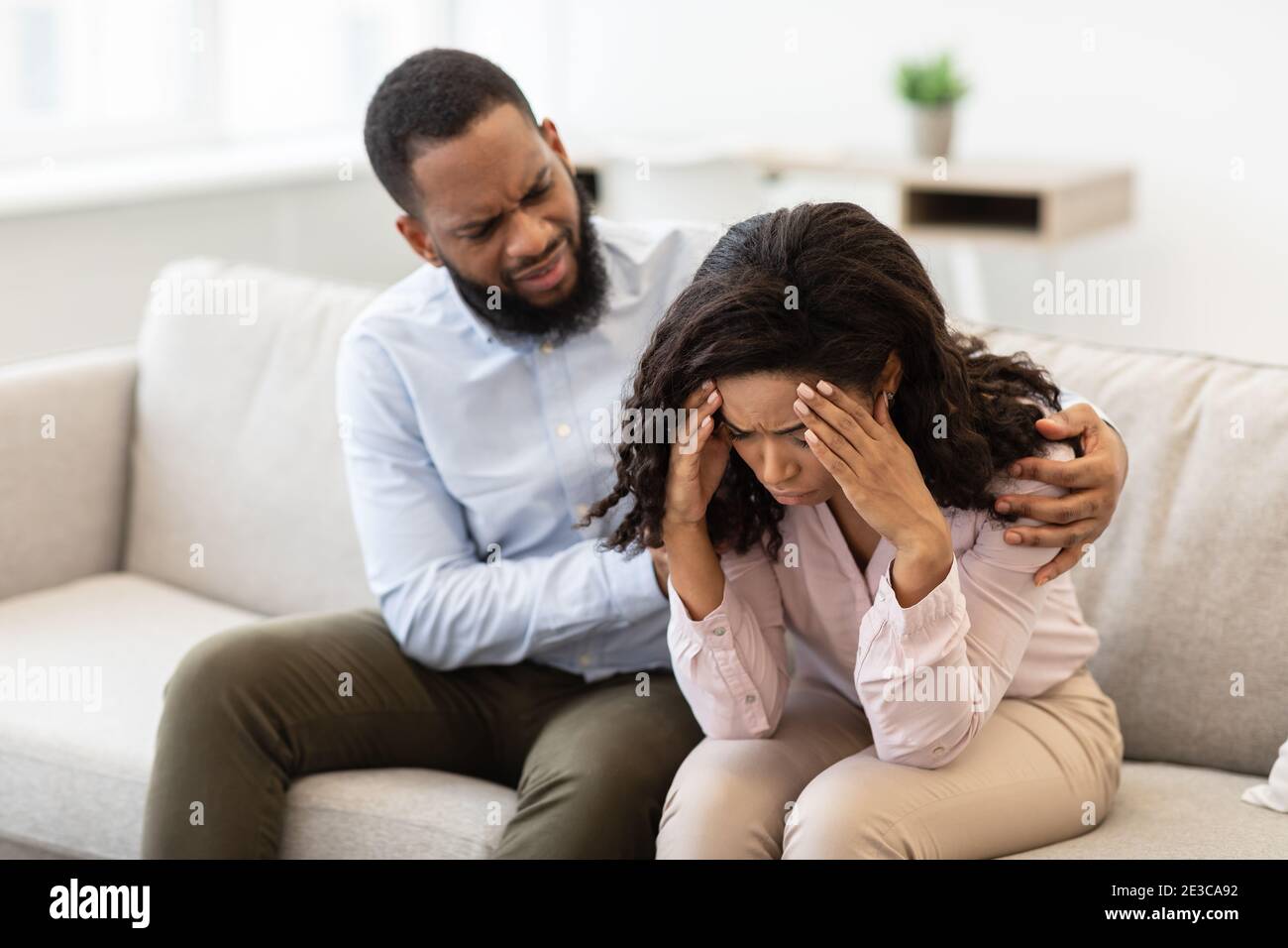 Afroamerikanischer Mann beruhigend und tröstend seine weinende gestresste Frau Stockfoto