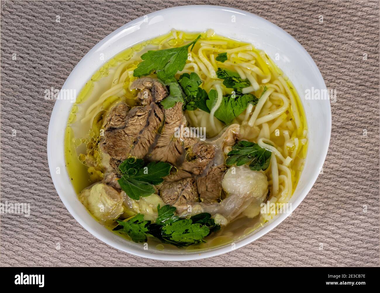 Draufsicht auf einen Teller mit hausgemachter Suppe mit Fleisch Und Nudeln Stockfoto