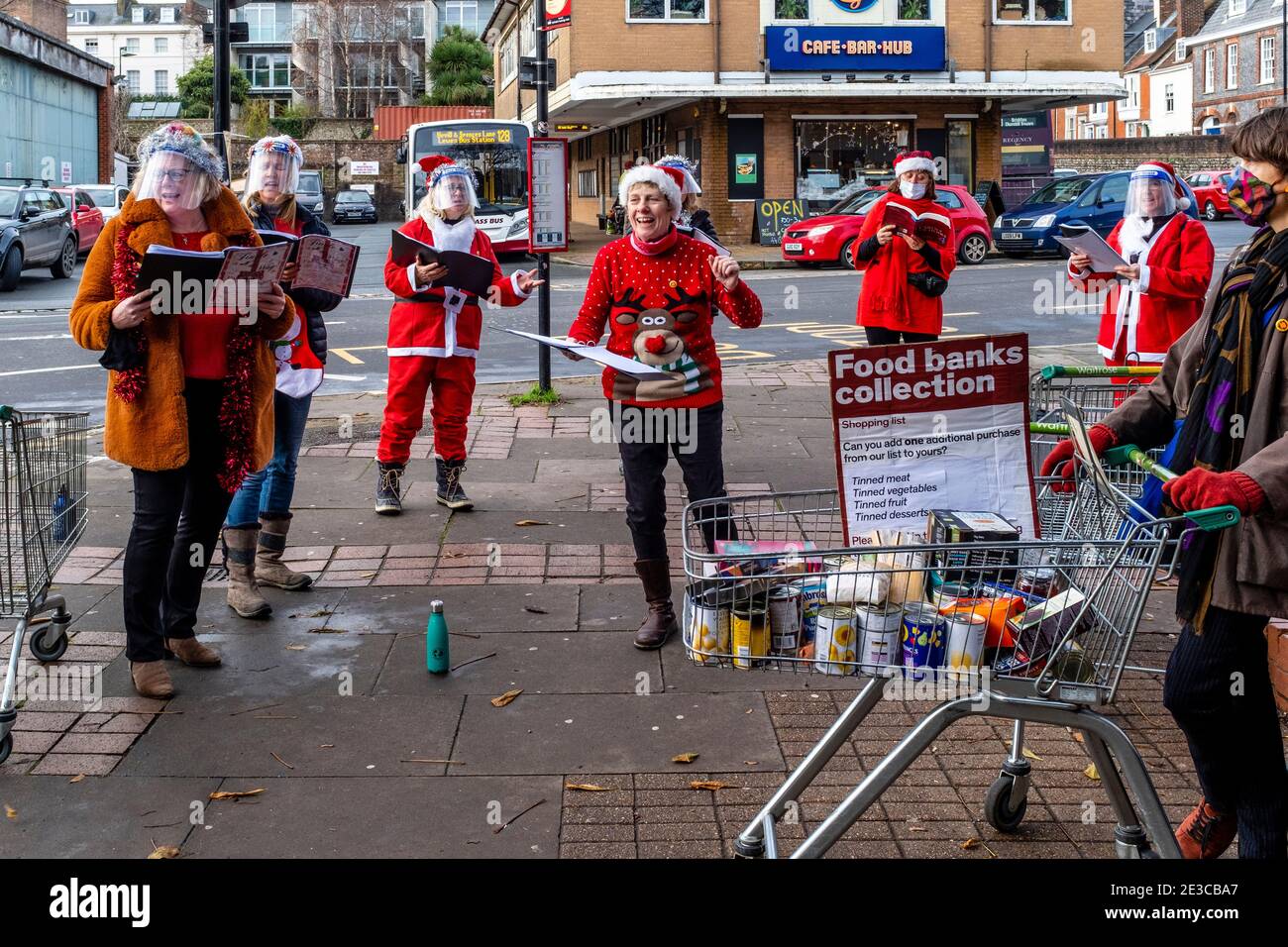 Lokale Frauen Sing Weihnachtslieder an EINEM Food Bank Collection Point außerhalb des Waitrose Supermarket, Lewes, East Sussex, Großbritannien. Stockfoto