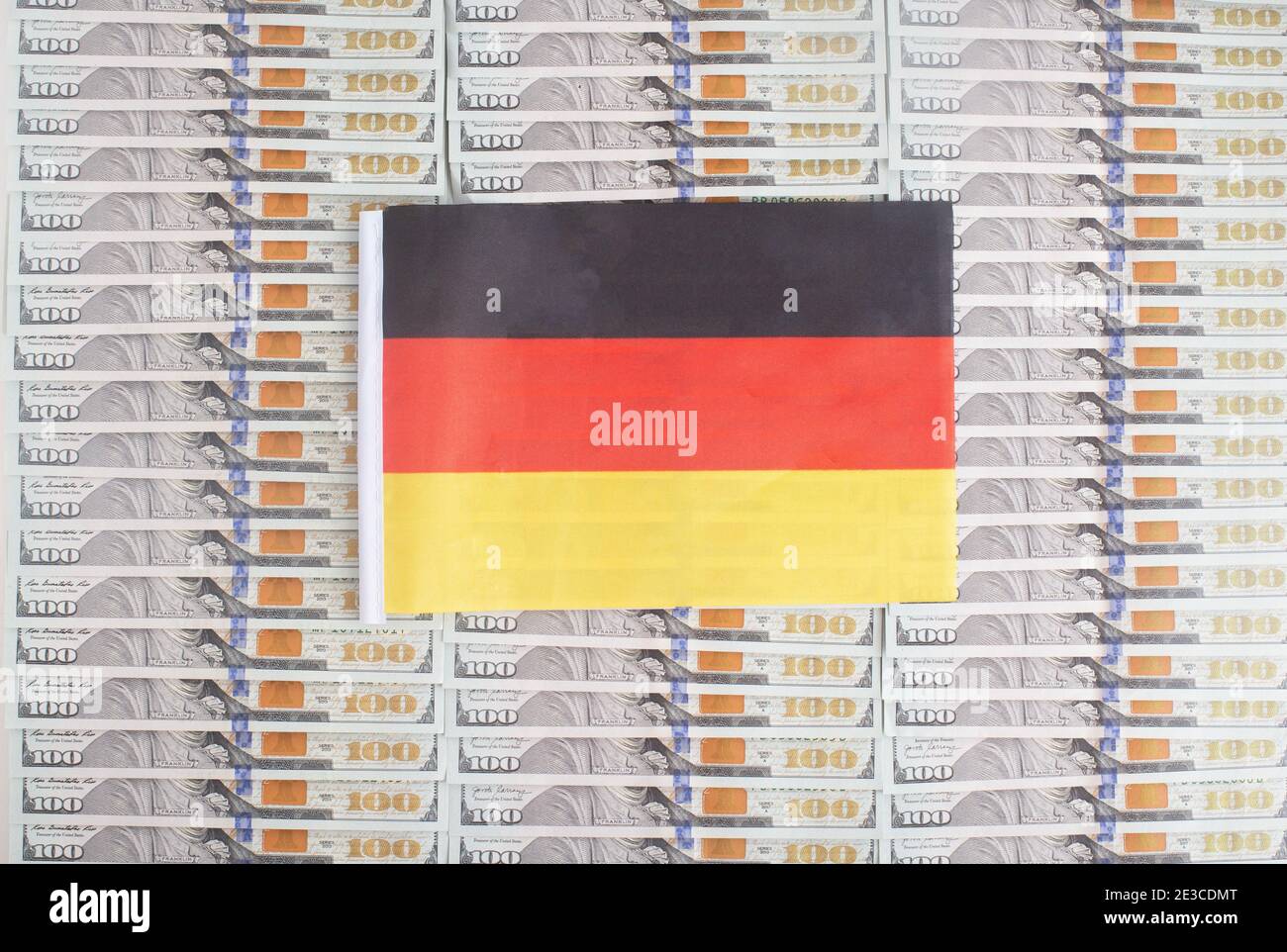 Deutschland Flagge auf einem Hintergrund von Dollar-Banknoten. Konzept des Verhältnisses des deutschen Geldes zum Dollar, der Wirtschaft des Landes, Stockfoto
