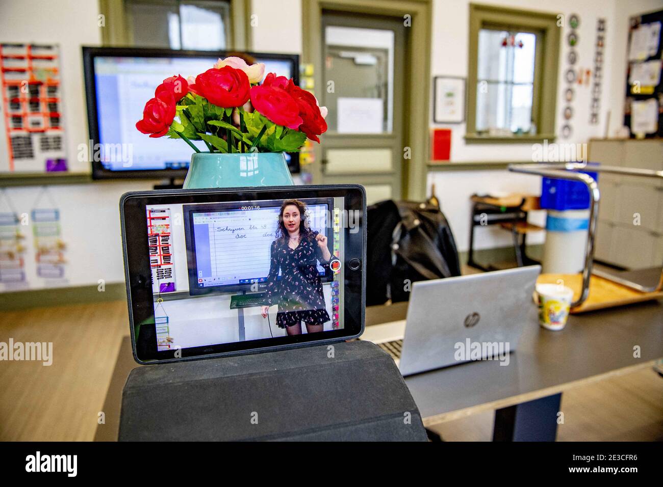 In einer Grundschule gibt ein Lehrer online Bildung mit Zoom während der leeren Klassenzimmer, inmitten COVID-19 Notfallmaßnahmen. Eltern haben eine harte Zeit mit den Kindern Kinderbetreuung in der Nähe von zu Hause Nachhilfe zu Hause Schulbildung zu Hause aufgrund der coron-Krise zu helfen. Rotterdam, Niederlande, am 18. Januar 2021. Foto von Robin Utrecht/ABACAPRESS.COM Stockfoto