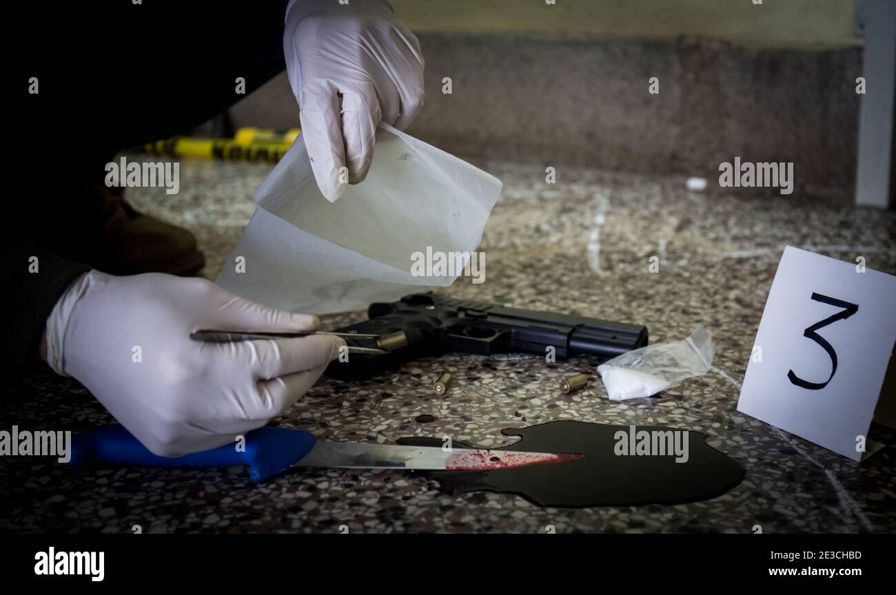 Tatort, Mord, Untersuchung, Polizei finden weggeworfene Waffe durch Mörder verwendet, als Beweis für Mord genommen, Polizei finden Drogen und blutiges Messer Stockfoto