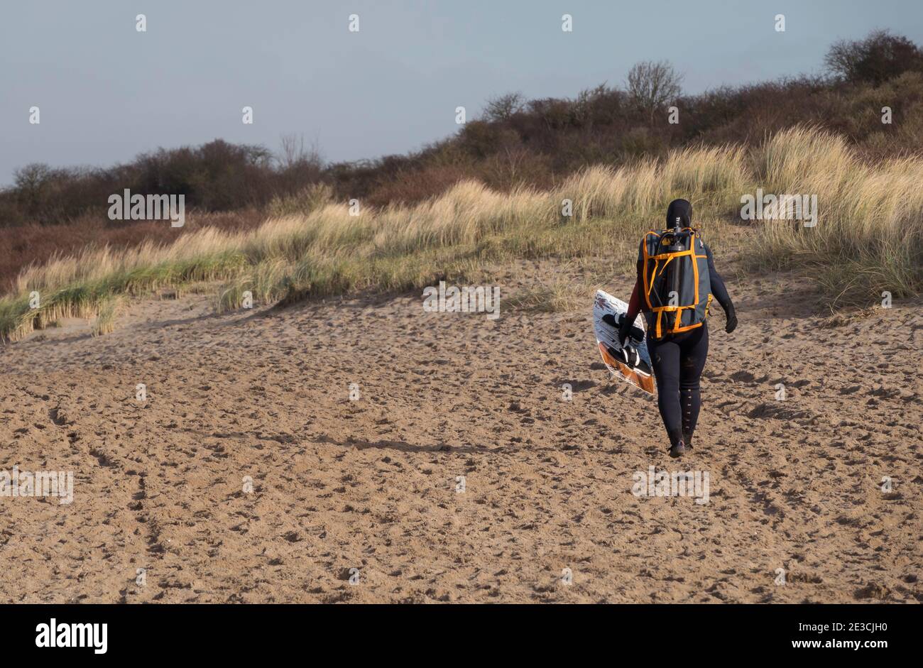 Oostvoorne:Holland,17-jan-2021:Frau mit Wellenbrett am Strand von oostvoorne spazieren, ist dies eine beliebte Palce für Wassersport Stockfoto