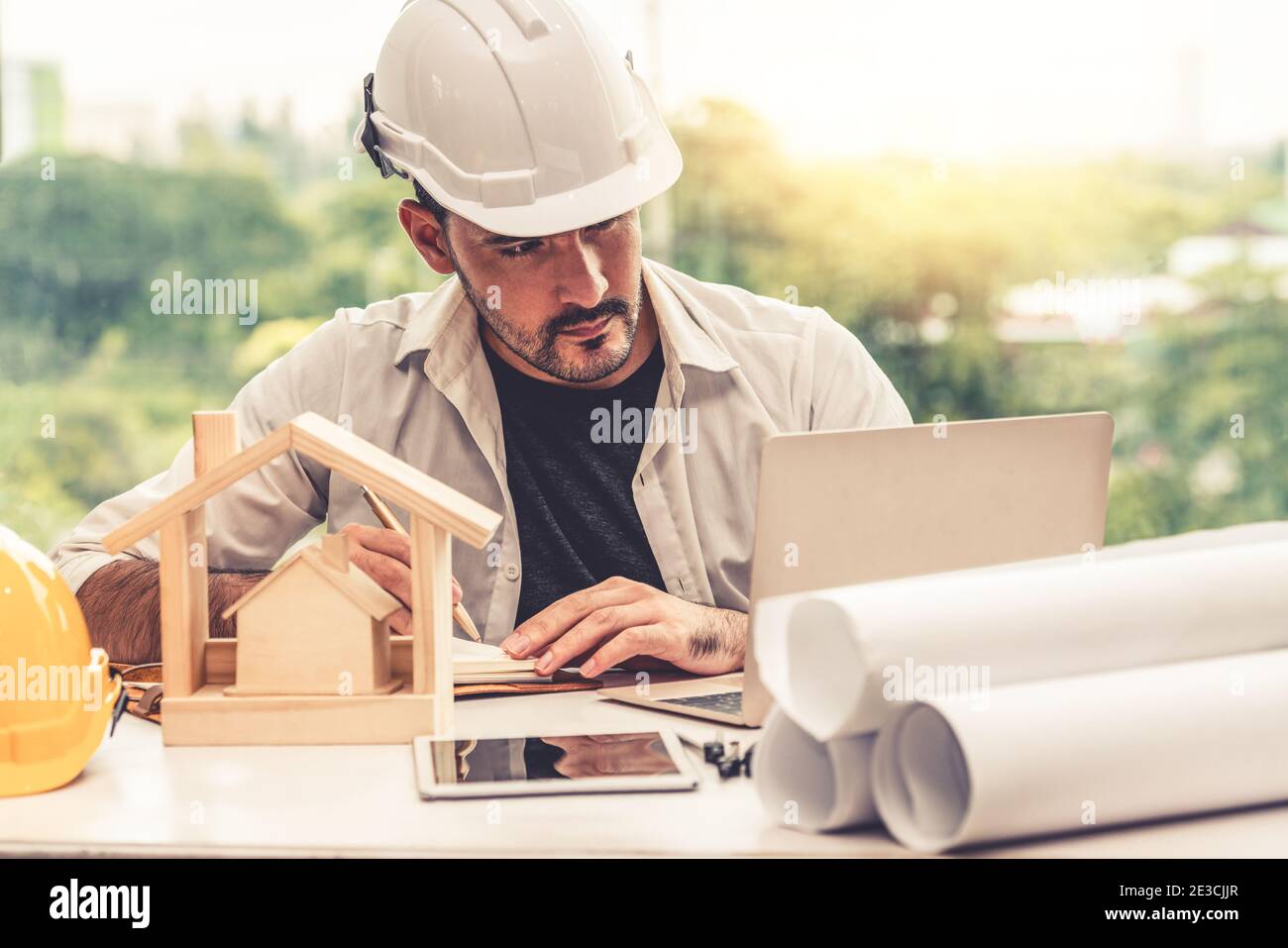 Junger Mann Architekt oder Ingenieur arbeiten am Schreibtisch mit Designer-Ausrüstung Innenarchitektur am Arbeitsplatz zu machen. Immobilien-Geschäft und Zivil Stockfoto