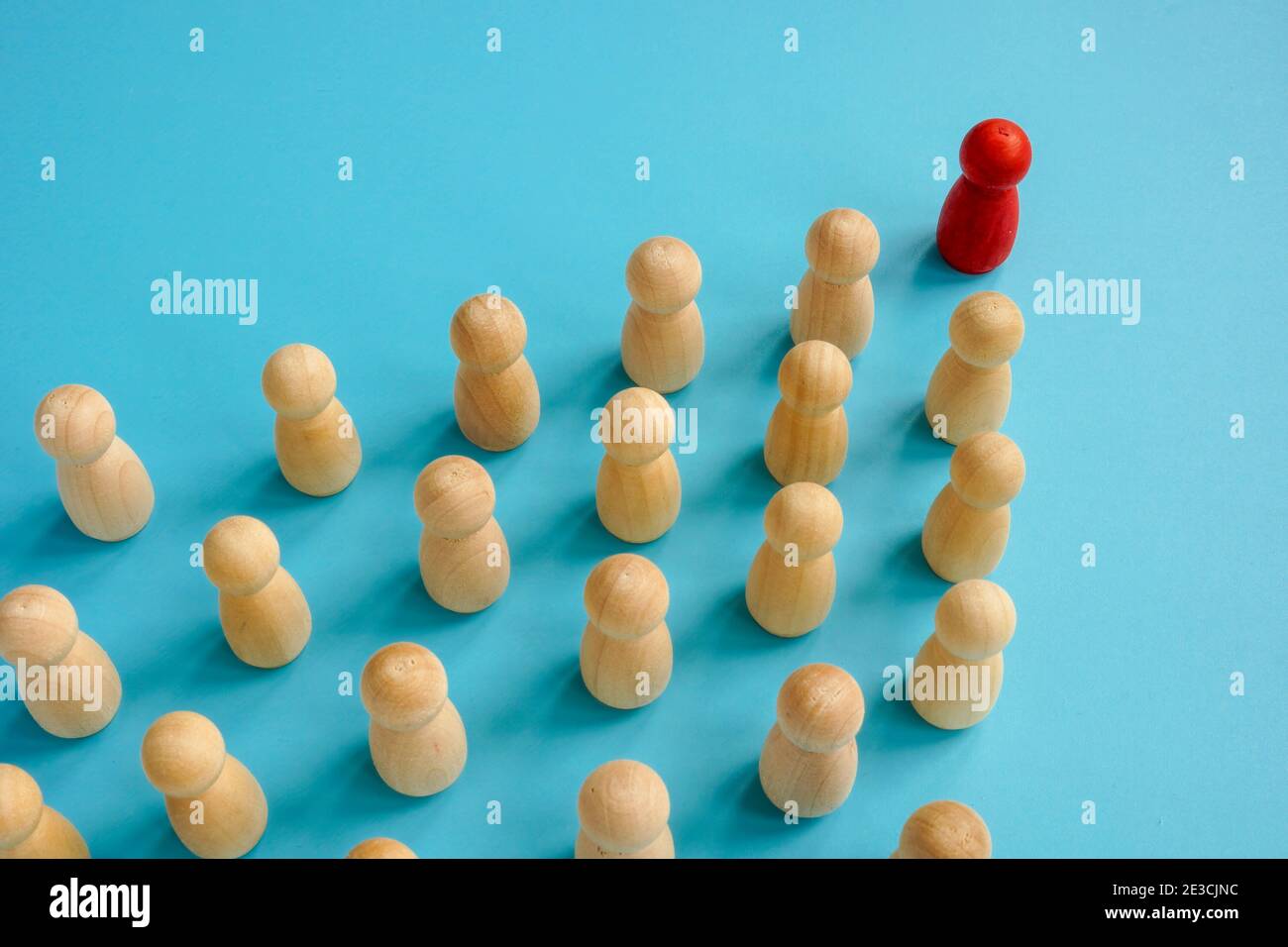 Rote Figur am Kopf der Holzfiguren. Führungs- und Teamkonzept. Stockfoto