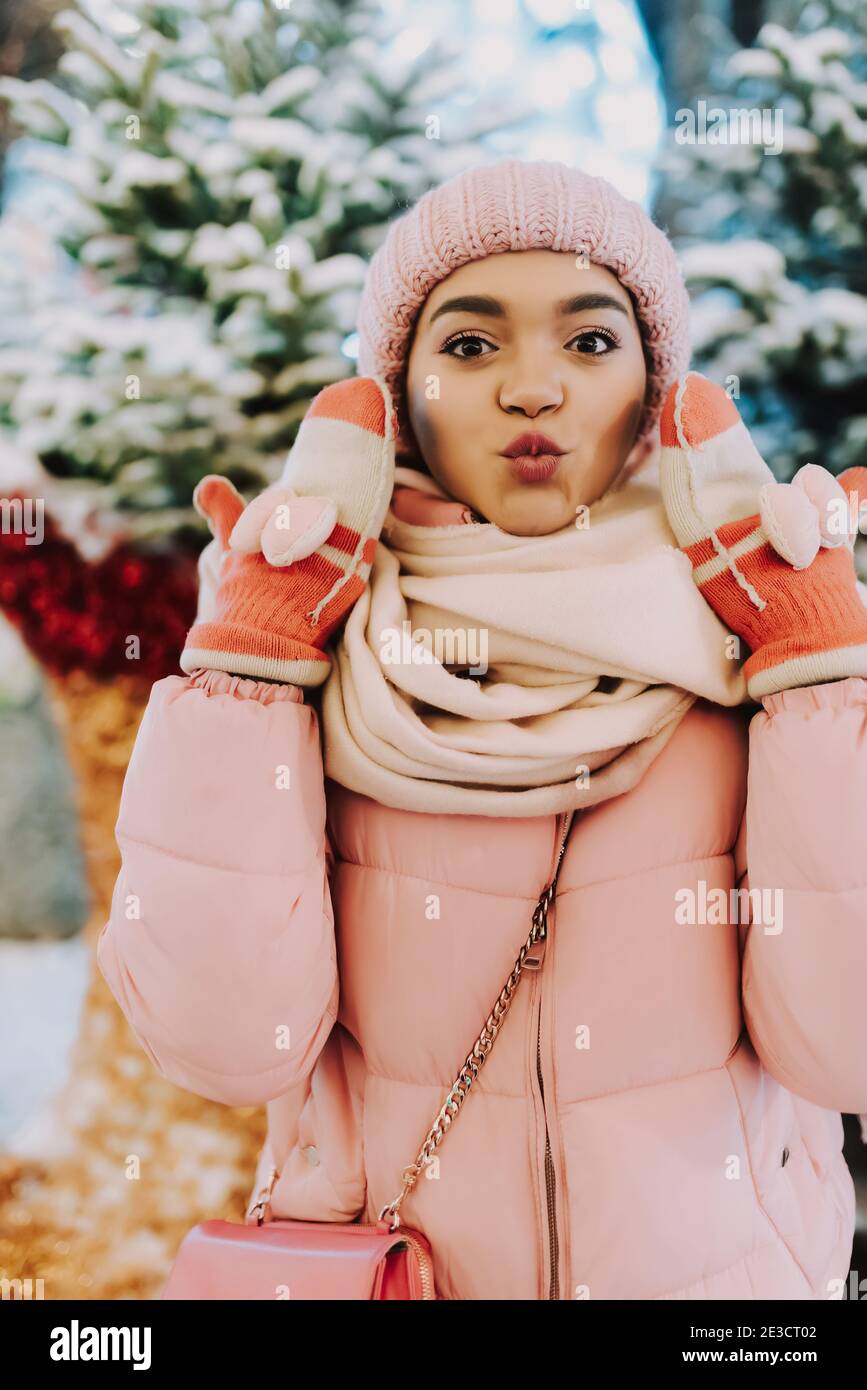 Junge attraktive afroamerikanische Frau, die während der Winterferien auf der Straße spazieren geht. Frohe Weihnachten und ein glückliches neues Jahr! Glücklich lächelndes Mädchen genießen Stockfoto