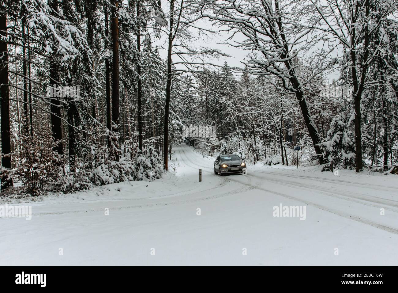 Auto auf einer gefährlichen Strecke mit Schnee bedeckt Und Eis.Snowy Straße durch Wald.Winterpanorama.Fahren in eisigen gefrorenen Landschaft.Bad Wetter war nicht so schön Stockfoto