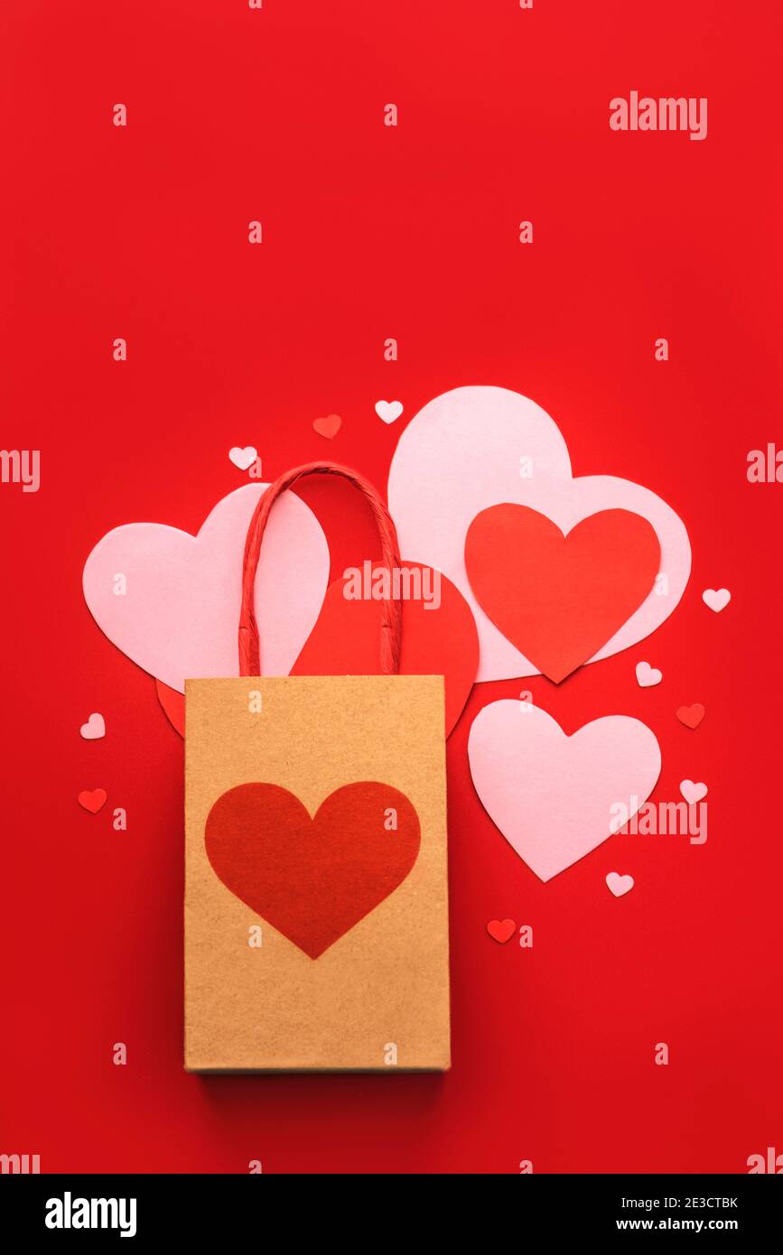Alles Liebe zum Valentinstag.Einkaufstasche mit einem Herzen auf rotem Hintergrund.Valentine Tageskonzept Stockfoto